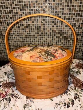 A vintage Longaberger tall round basket with padded floral lid.